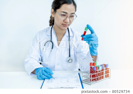 The doctor hand holding the blood tube and records examination results and medication usage of the patient on the chart, medical check-up concept 80529734