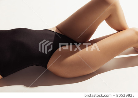 Close up female body in black underwear over white background. Close up female body in black underwear over white background. 80529923