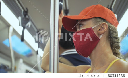 Woman travel caucasian ride at overground train airtrain with wearing protective medical mask. Girl tourist at airtrain with respirator. People mask. Woman travel caucasian ride at overground train airtrain with wearing protective medical mask. Girl tourist at airtrain with respirator. People mask. 80531388