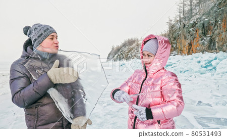 Couple has fun during winter walk against background of ice of f Couple has fun during winter walk against background of ice of f 80531493