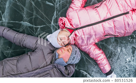 Couple has fun during winter walk against background of ice of f 80531526
