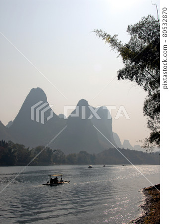 Boats on the Li River between Guilin and Yangshuo in Guangxi Province, China. The karst hills and river scenery have provided inspiration for artists and poets. Sunlight on the Li River, Guilin. Boats on the Li River between Guilin and Yangshuo in Guangxi Province, China. The karst hills and river scenery have provided inspiration for artists and poets. Sunlight on the Li River, Guilin. 80532870