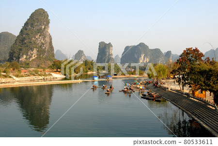 Bamboo rafts on the Yulong River near Yangshuo, Guilin in Guangxi Province, China. This is the terminus for the bamboo raft ride along the Yulong River, a popular activity for visitors to Yangshuo. Bamboo rafts on the Yulong River near Yangshuo, Guilin in Guangxi Province, China. This is the terminus for the bamboo raft ride along the Yulong River, a popular activity for visitors to Yangshuo. 80533611