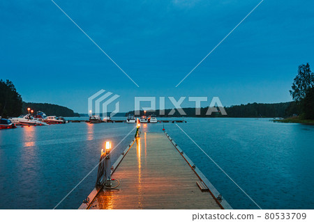 Sweden. Beautiful Wooden Pier Near Lake In Summer Evening Night. Lake Or River Landscape Sweden. Beautiful Wooden Pier Near Lake In Summer Evening Night. Lake Or River Landscape 80533709