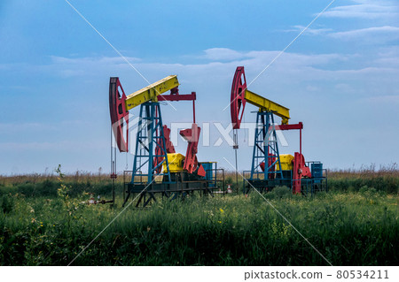 pumpjacks operating at an oil well in field outdoors pumpjacks operating at an oil well in field outdoors 80534211