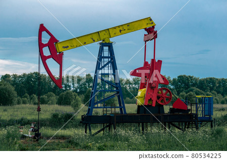 pumpjack operating at an oil well in field outdoors pumpjack operating at an oil well in field outdoors 80534225