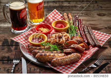 Fried sausages, potato wedges, stewed cabbage, sauces as beer snack 80534650