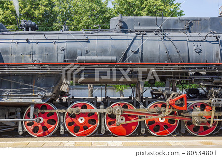 Black retro steam locomotive at the railway station on a sunny day 80534801