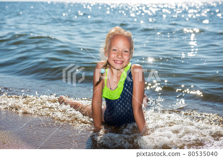 Little girl is laughing and swimming at sea on a sunny day 80535040