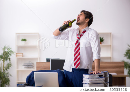 Young alcohol addicted male employee working in the office 80535528