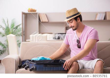 Young man preparing for trip at home Young man preparing for trip at home 80535781