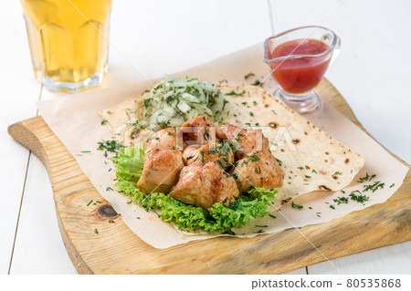 Main course of chicken brisket pieces served with greens and sauce on a wooden board Main course of chicken brisket pieces served with greens and sauce on a wooden board 80535868