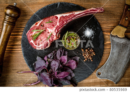 Dry aged raw tomahawk beef steak with ingredients for grilling Dry aged raw tomahawk beef steak with ingredients for grilling 80535989