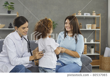 Female doctor attaches a stethoscope to the girl's back and listens to the heartbeat and lungs. Female doctor attaches a stethoscope to the girl's back and listens to the heartbeat and lungs. 80537065