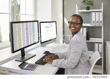 Portrait of happy african american female accountant at her workplace in the office. 80537068