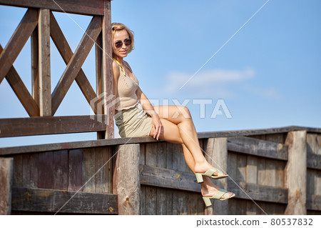 Elegant white woman 48 years old sits on roof outdoors. Elegant white woman 48 years old sits on roof outdoors. 80537832