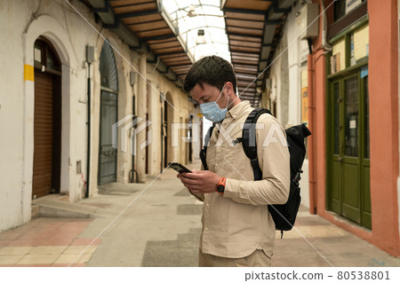 Masked male tourist walks at closed market during coronavirus pandemic, lockdown on Cyprus. Man in mask walks through market in city center. No tourists, bankruptcy of small businesses under COVID 19 80538801