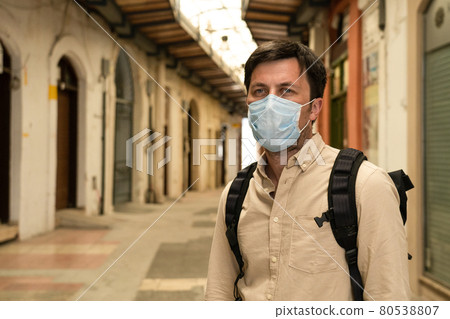 Masked male tourist walks at closed market during coronavirus pandemic, lockdown on Cyprus. Man in mask walks through market in city center. No tourists, bankruptcy of small businesses under COVID 19 80538807