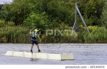 Teenager wakeboarding on a lake - Brwinow, Masovia, Poland 80540850