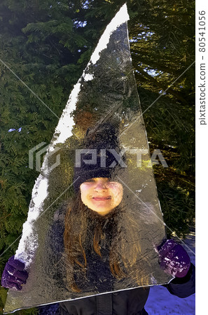 Girl hidden behind piece of ice floe in Choczewo, Pomerania, Poland Girl hidden behind piece of ice floe in Choczewo, Pomerania, Poland 80541056
