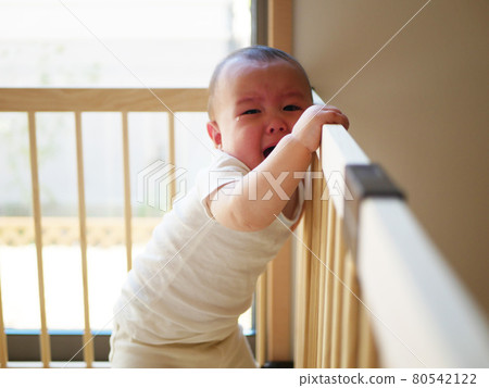 Half-baby crying while holding in the playpen 80542122