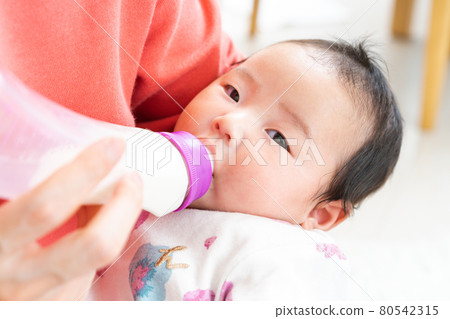 嬰兒在奶瓶裡喝牛奶 嬰兒在奶瓶裡喝牛奶 80542315