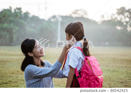 primary school student taken by mother to school in the morning primary school student taken by mother to school in the morning 80542425