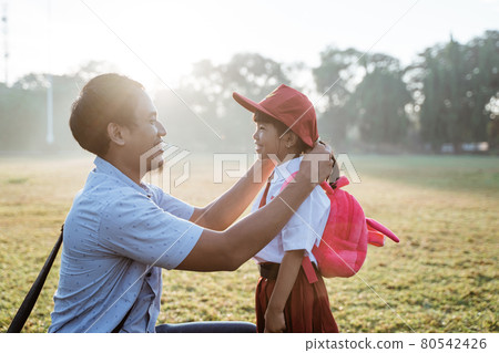 father taking her daughter to primary school in the morning father taking her daughter to primary school in the morning 80542426