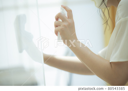 A restaurant clerk who disinfects 80543385