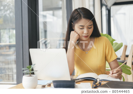 Young collage student using computer and mobile device studying online. Young collage student using computer and mobile device studying online. 80544465