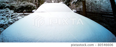 Radiator bonnet and windscreen of an SUV after a light snowfall, wide-angle view 80546606