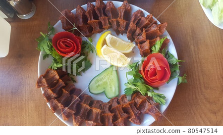 Cig kofte (raw meatball) with lettuce, tomato, pickle and lemon on the white plate. Turkish food Raw Meat ( Cig Kofte ) from traditional Turkish cuisine Cig kofte (raw meatball) with lettuce, tomato, pickle and lemon on the white plate. Turkish food Raw Meat ( Cig Kofte ) from traditional Turkish cuisine 80547514