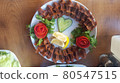 Cig kofte (raw meatball) with lettuce, tomato, pickle and lemon on the white plate. Turkish food Raw Meat ( Cig Kofte ) from traditional Turkish cuisine 80547515