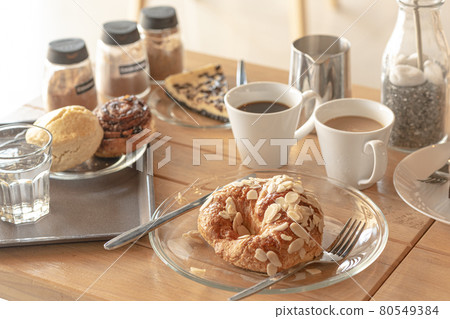 Sweet Croissant almond server with americano and latte and chocolate tart on wooden desk in cafe. Sweet Croissant almond server with americano and latte and chocolate tart on wooden desk in cafe. 80549384