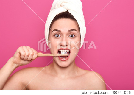Image of funny magnetic female holding her wooden toothbrush in cavity, doing everyday procedure, enjoying process, caring about her health, opening her eyes widely with excitement. Dental concept. Image of funny magnetic female holding her wooden toothbrush in cavity, doing everyday procedure, enjoying process, caring about her health, opening her eyes widely with excitement. Dental concept. 80551006
