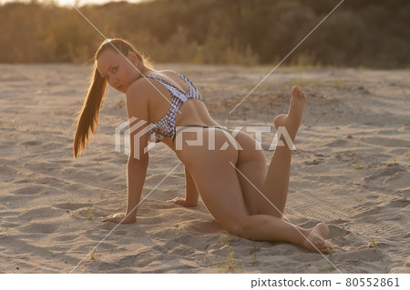 Relaxed woman in swimsuit resting on sand 80552861