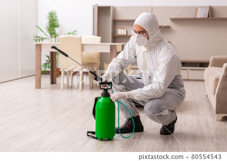 Young male contractor doing pest control at home 80554543