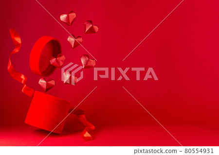 Red glitter paper hearts fly from box, flying red velvet box with red silk ribbon, horizontal 80554931