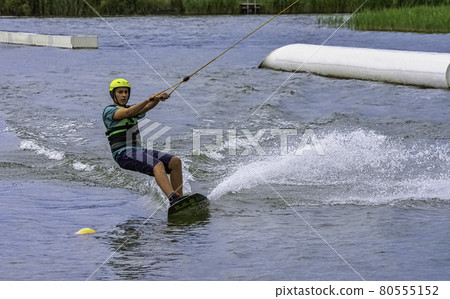 Teenager wakeboarding on a lake - Brwinow, Masovia, Poland 80555152