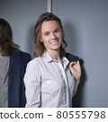 portrait of an emotional business woman taking off her jacket, smiling happily 80555798