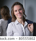 portrait of an emotional business woman taking off her jacket, smiling happily 80555802