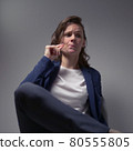 cool business woman in a jacket sitting in a chair on a dark background 80555805
