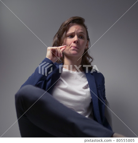 cool business woman in a jacket sitting in a chair on a dark background cool business woman in a jacket sitting in a chair on a dark background 80555805