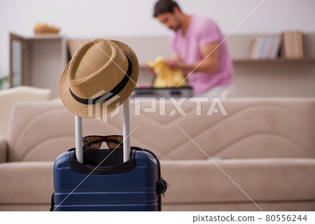 Young man preparing for trip at home Young man preparing for trip at home 80556244