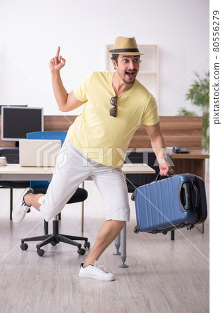 Young male employee preparing for trip at workplace 80556279