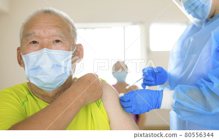 Doctor doing vaccine injection to senior man Doctor doing vaccine injection to senior man 80556344