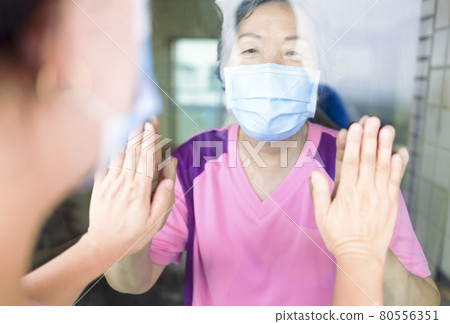 Senior woman mask window coronavirus covid-19 Senior woman mask window coronavirus covid-19 80556351