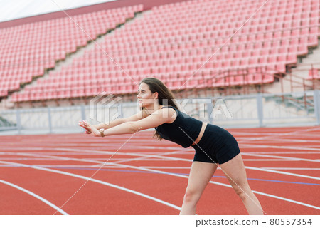 Young, beautiful girl athlete in sportswear is training at the stadium Young, beautiful girl athlete in sportswear is training at the stadium 80557354