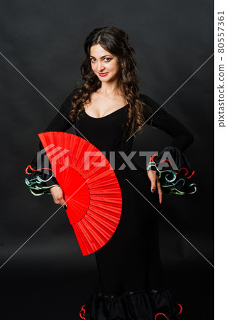 Portrait of beautiful young woman dancing flamenco in studio 80557361