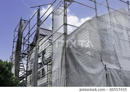 Scaffolding and net during residential construction 80557435